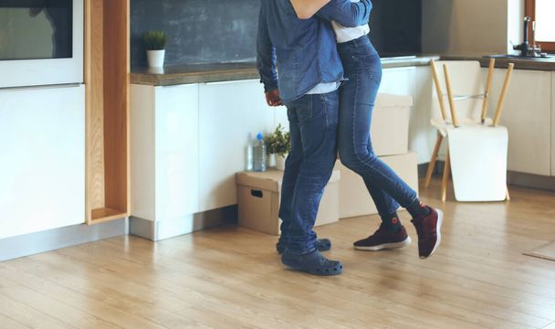 Happy couple hugging in their new house - 写真・画像