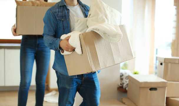 Couple holding boxes for moving the hands and looking inside box - Photo, Image
