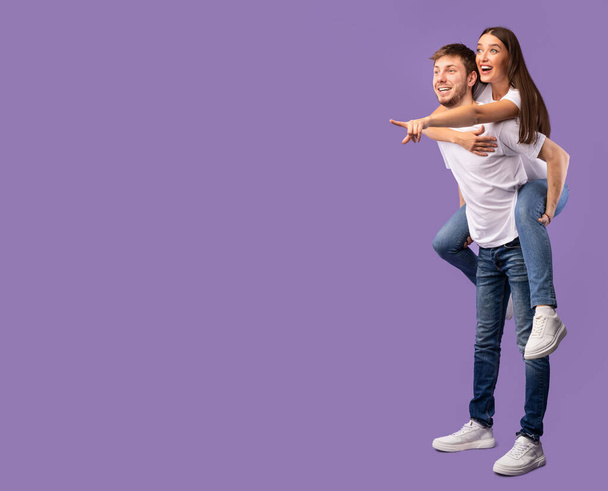 Glückliches Paar zeigt mit dem Finger auf freien Raum - Foto, Bild