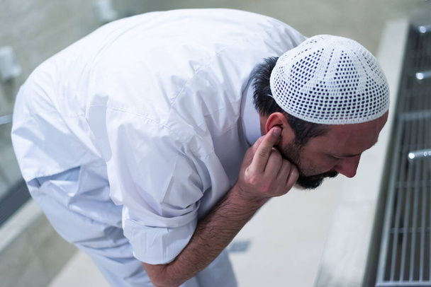 Мусульманин принимает омовение для молитвы. Церемония искупления исламского религиозного обряда. Молодой мусульманин совершает омовение перед молитвой
. - Фото, изображение