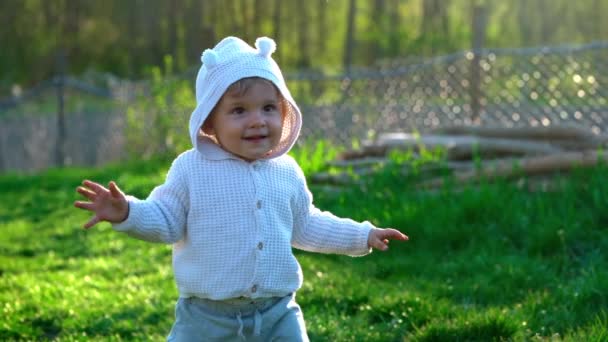 Yürüyen, gülümseyen küçük bir çocuğun parkta veya yeşil bir bahçede güzel bir portresi. İlk adımlar. Sevgili oğul, aile, bebek konsepti.. - Video, Çekim