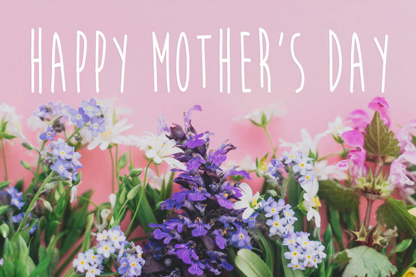 Ευτυχισμένο το μήνυμα της Μητέρας, ευχετήρια κάρτα. Πολύχρωμο άνοιξη λουλούδια σύνορα σε ροζ φόντο επίπεδη θέσει με σήμα χαιρετισμού. Floral ευχετήρια κάρτα. Χαρούμενη Ημέρα Μητέρας - Φωτογραφία, εικόνα