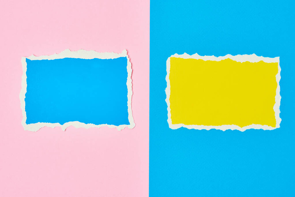 青とピンクの背景に2枚の裂けた紙が縁板を引き裂いた。カラーペーパー付きテンプレート - 写真・画像