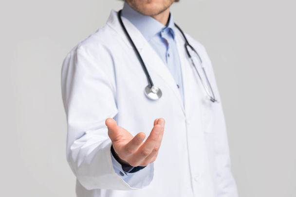 Männlicher Arzt mit virtuellem Objekt in der Hand unkenntlich gemacht - Foto, Bild