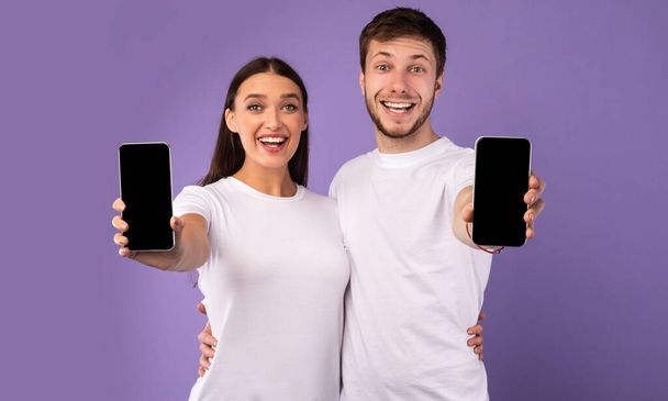 Щаслива пара, що показує порожній екран мобільного телефону на камеру
 - Фото, зображення