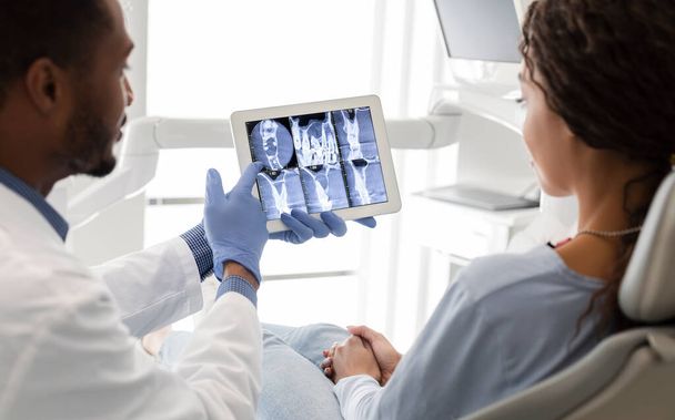 Dentysta i pacjent patrzący na obraz rentgenowski na ekranie cyfrowym - Zdjęcie, obraz