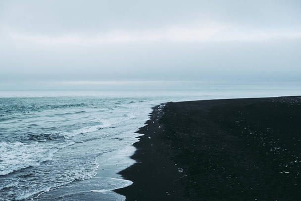 Calma praia de areia preta na Islândia
 - Foto, Imagem