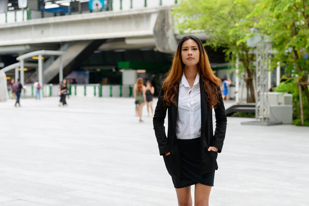 Portrait of young beautiful Asian businesswoman in the city streets outdoors - Fotografie, Obrázek