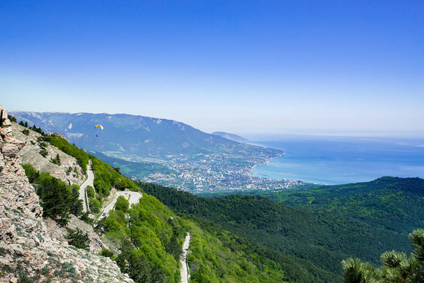 Vista da cidade costeira de Yalta com parapentes
 - Foto, Imagem