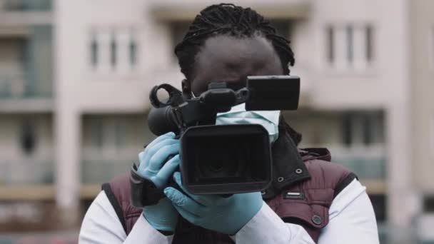 african cameraman recording with professional camera. Reporting about covid-19 outbreak - Footage, Video