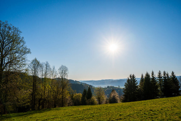 green field in the mountains with a valley below and the sun on the horizon, czech - Photo, Image