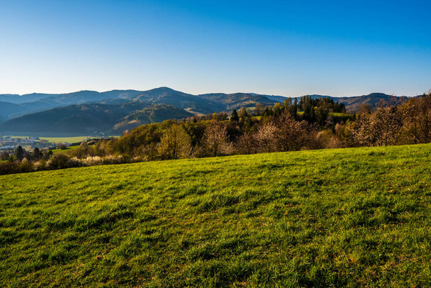 green field in the mountains with a valley below and the sun on the horizon, czech - Photo, image
