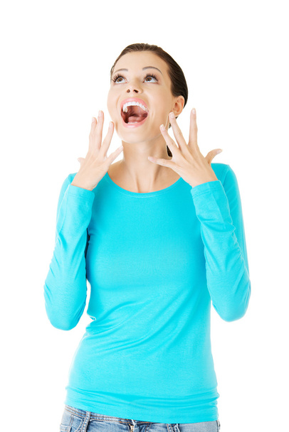 Beautiful casual woman screaming, looking up. - Photo, image