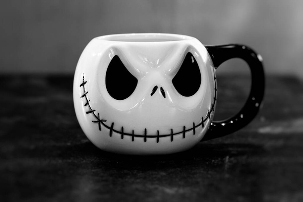 Ein Halloween-Gesicht mit aufgenähtem Mund auf einem Trinkbecher, schwarz-weiß - Foto, Bild