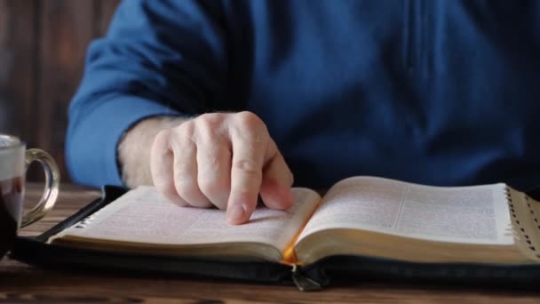 A keresztény ember a Bibliából olvas és ír. Biblia tanulmány egy csésze kávéval - Felvétel, videó