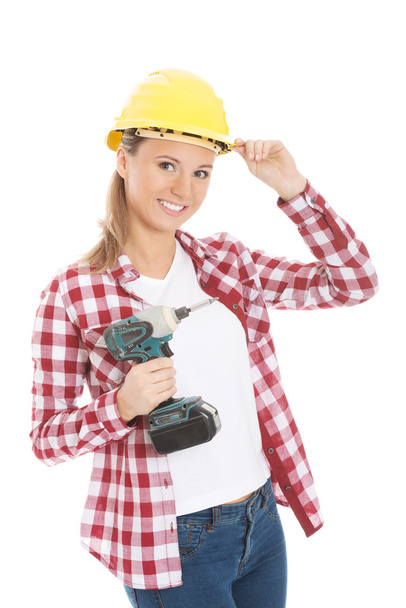 Young casual woman holding drill and wearing safety helmet. - Fotografie, Obrázek