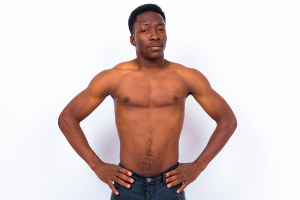 Studio shot of young handsome African man shirtless against white background - 写真・画像