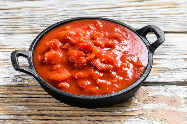 Gesneden rode tomaten in blik in een pan. Witte achtergrond. Bovenaanzicht. - Foto, afbeelding