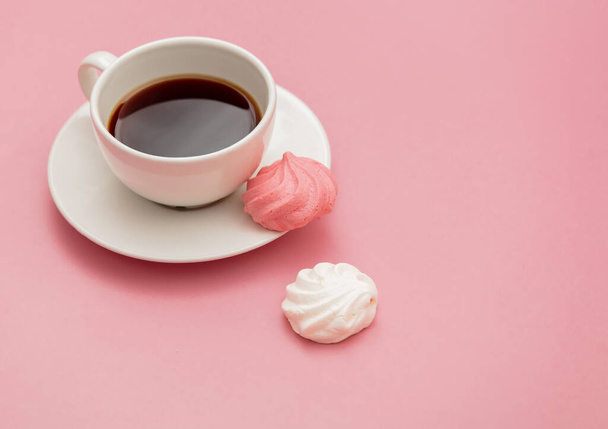 Baiser und Tasse Kaffee auf rosa Hintergrund - Foto, Bild