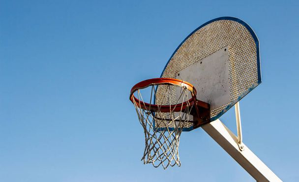 Mavi gökyüzü arka planına sahip bir sokak kortunda klasik basketbol ringi. Aşağı bakış. Seçici Odaklanma. - Fotoğraf, Görsel