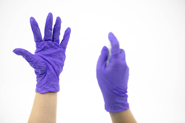 Orvos kezet mosni kesztyűben alkoholos fertőtlenítő spray fehér háttér - Fotó, kép