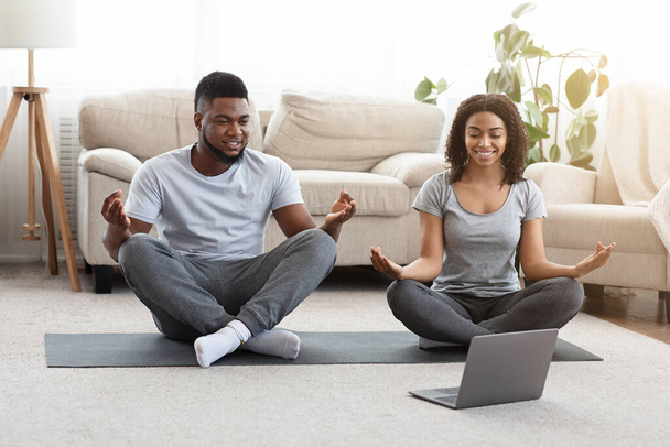 Zwarte Millennial Paren die Yoga Online met Instructeur op Laptop oefenen - Foto, afbeelding