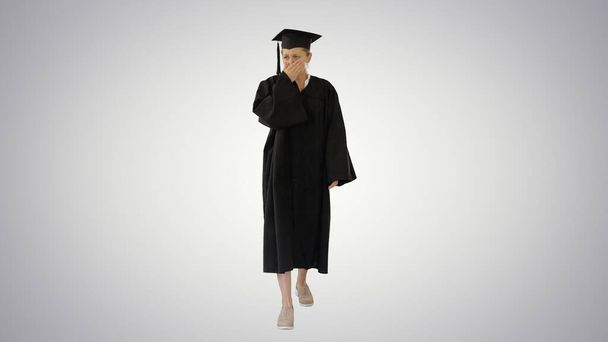 Young graduate woman sick and coughing while walking on gradient background. - Фото, изображение