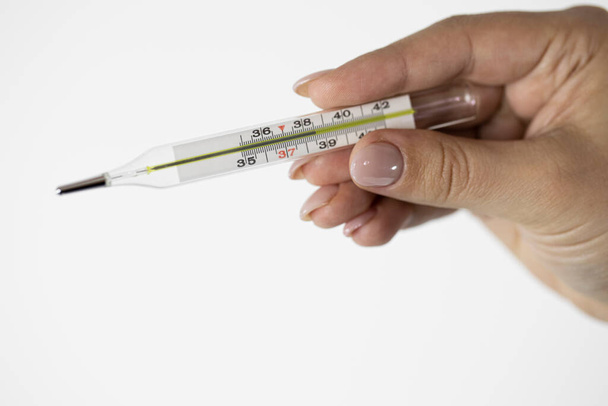 Kwik thermometer in vrouwelijke hand met hoge temperatuur boven 38 graden - Foto, afbeelding