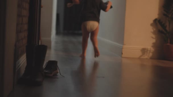 Kleines Mädchen nimmt Stiefel und läuft weg, um es anzuprobieren - Filmmaterial, Video