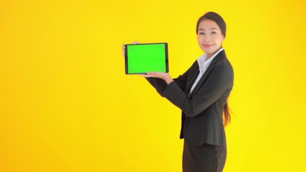 кадры красивой азиатской бизнесвумен держит планшет с чистым экраном изолированы на желтый
 - Кадры, видео