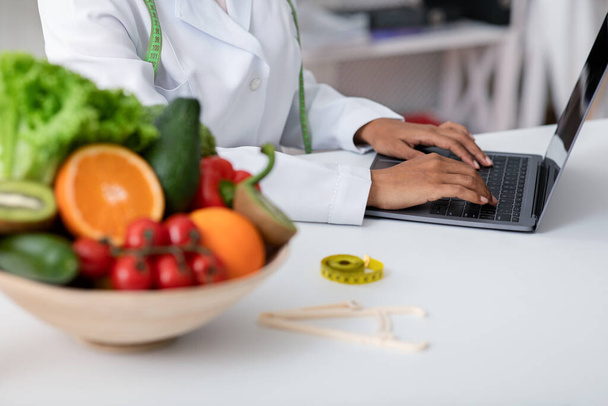Cropped of fresh fruits and vegetables and working online doctor - 写真・画像