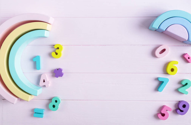 Arco-íris de brinquedo de madeira, blocos, arco de cor pastel no fundo rosa. Natural sem brinquedos de plástico para o desenvolvimento da criatividade. Deitado plano, vista superior. Jogos educativos para jardim de infância, crianças pré-escolares
 - Foto, Imagem