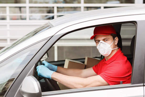 Postal delivery. Courier in protective mask driving car - Фото, изображение