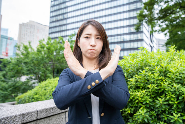 Asiatico (giapponese) giovane donna ufficio lavoratore attraversando le mani diagonalmente e firmando "NG
" - Foto, immagini