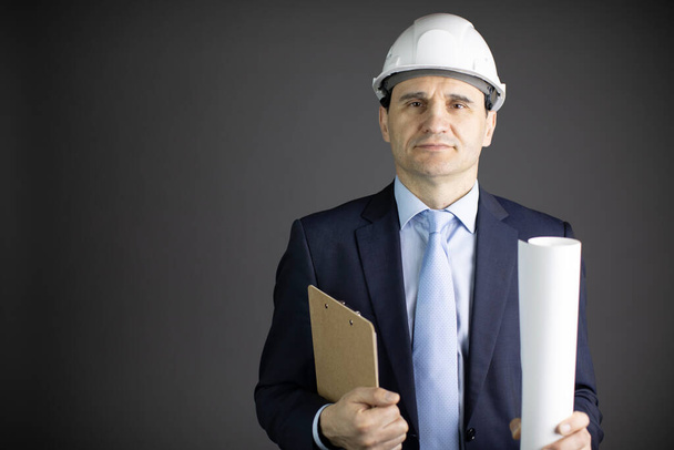 Ingeniero de construcción en sombrero duro sostiene portapapeles plano rollo con espacio de texto
 - Foto, imagen