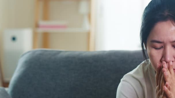 Depressed pláč Asijské obchodní žena zdůraznil s bolestí hlavy sedí na pohovce v obývacím pokoji v domě, když sociální distancing pobyt doma a vlastní karantény čas, coronavirus koncept. - Záběry, video