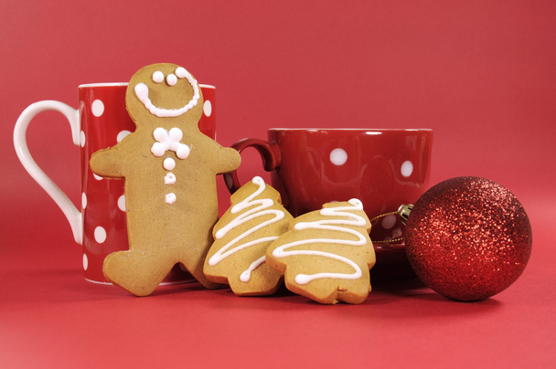赤の水玉のコーヒーのマグカップと紅茶のカップでのジンジャーブレッドのクッキー - 写真・画像