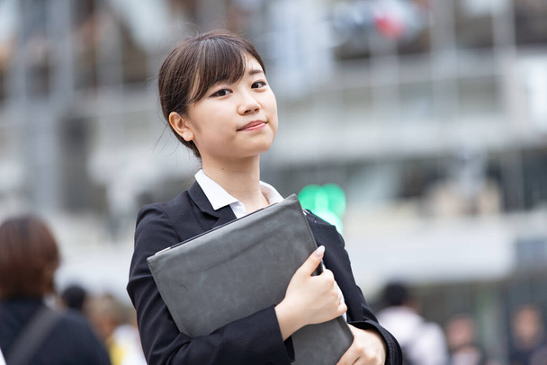 Aziatisch (Japans) jonge vrouwelijke student op zoek naar een baan - Foto, afbeelding