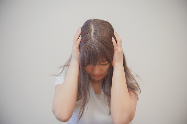 Asiática joven mujer deprimida y bajó para ocultar su cara con su pelo
 - Foto, imagen