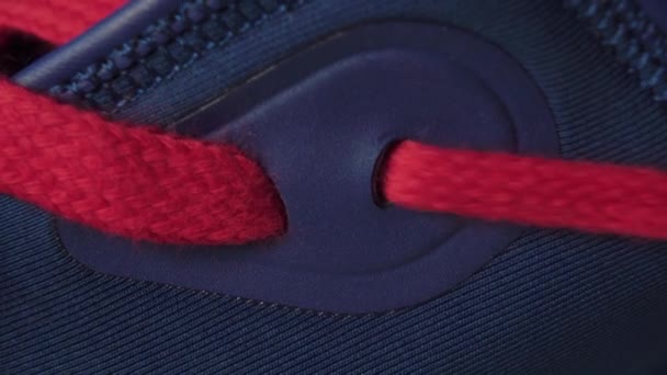 Lacing blue sneakers with bright red laces close up. Macro shot - Záběry, video