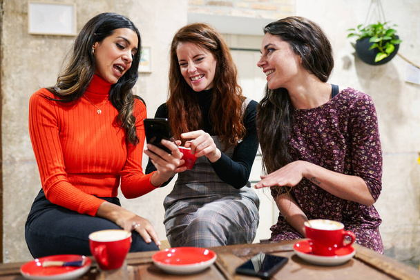 Három boldog barátból álló csoport kávézik egy kávézóban.. - Fotó, kép