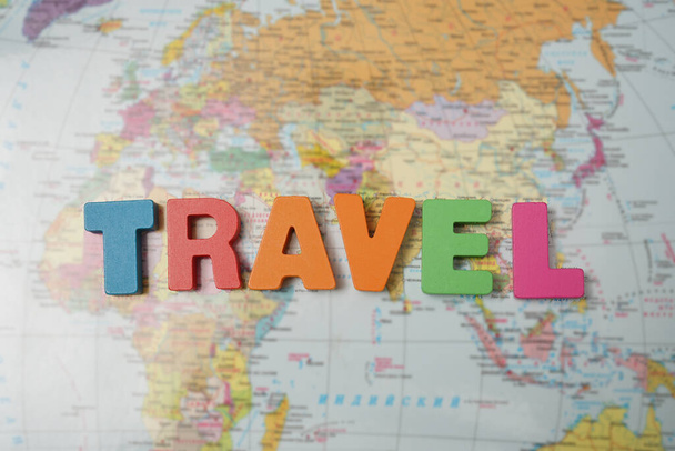word travel made from  letters. world map background. top view. - Фото, изображение