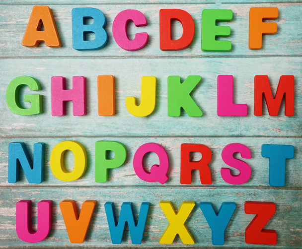 Wooden letters of English alphabet on  board  background, top view - Фото, зображення