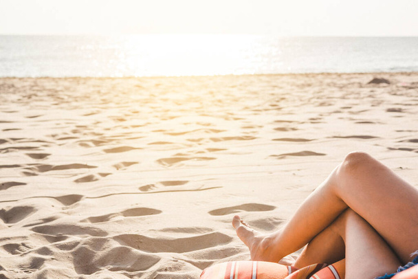 Bella giovane donna gambe riposo e relax sulla spiaggia. Se
 - Foto, immagini