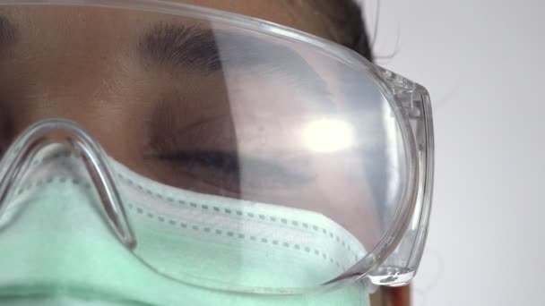 Canadian nurse with medical mask during the COVID-19 coronavirus pandemic. Essential services at hospitals and Care Homes. Extreme macro close up at the eye. Woman in the disposable mask. - Πλάνα, βίντεο