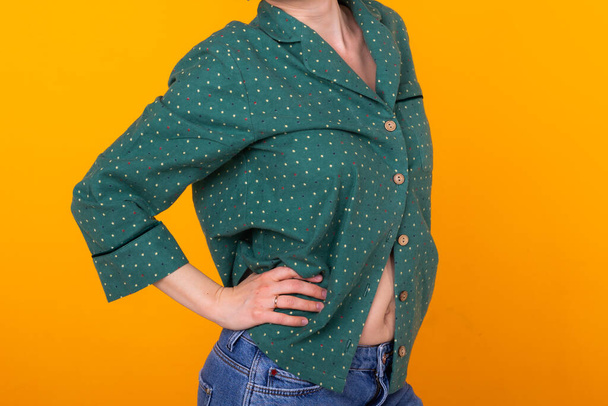 Крупним планом молода жінка в зеленому домашньому одязі. Ізольовані на жовтому тлі
. - Фото, зображення