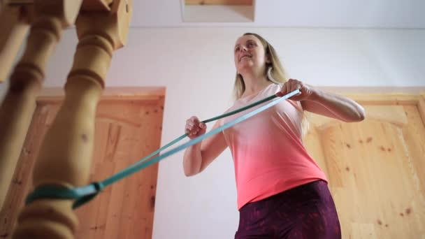 Mulher em casa tem treinamento com faixa elástica
 - Filmagem, Vídeo