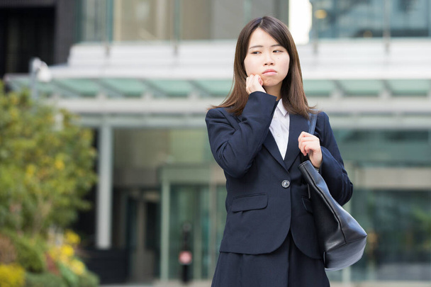 Azjatka (japońska) młoda pracownica o problematycznym wyrazie twarzy - Zdjęcie, obraz