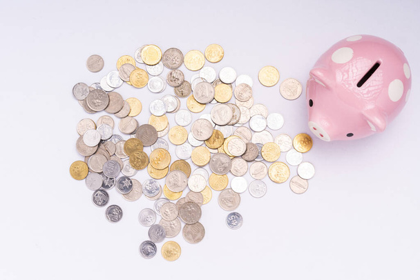 Piggy bank met verspreide munten op witte achtergrond - Foto, afbeelding