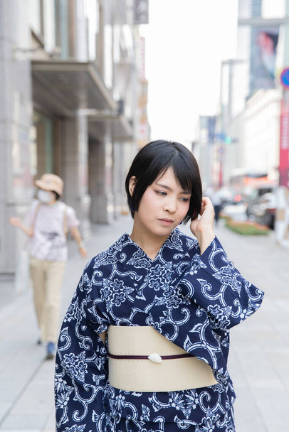Asiático (Japonês) mulher indo para a cidade vestindo um yukata (traje tradicional japonês
) - Foto, Imagem